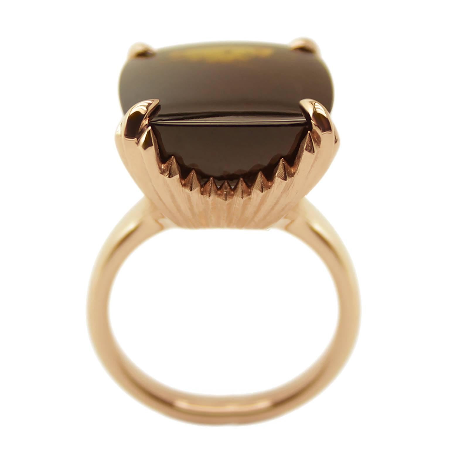 A stunning 5.5ct buff top deep brown tourmaline stone, set into a four claw 9ct rose gold ring.

The detail carries on underneath to create a raised mount of grooves and filed angles. This really catches the light as you move the ring. Its of a
