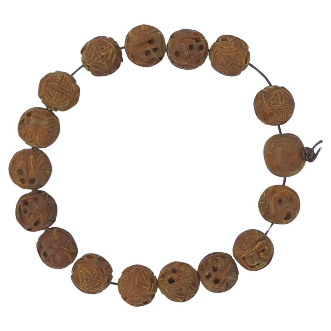 This finely crafted vintage mid-century bracelet features 17 intricately carved sandalwood beads (D: 12mm), each a miniature work of art. The beads are meticulously shaped and carved, displaying a level of craftsmanship that speaks to the artisan's