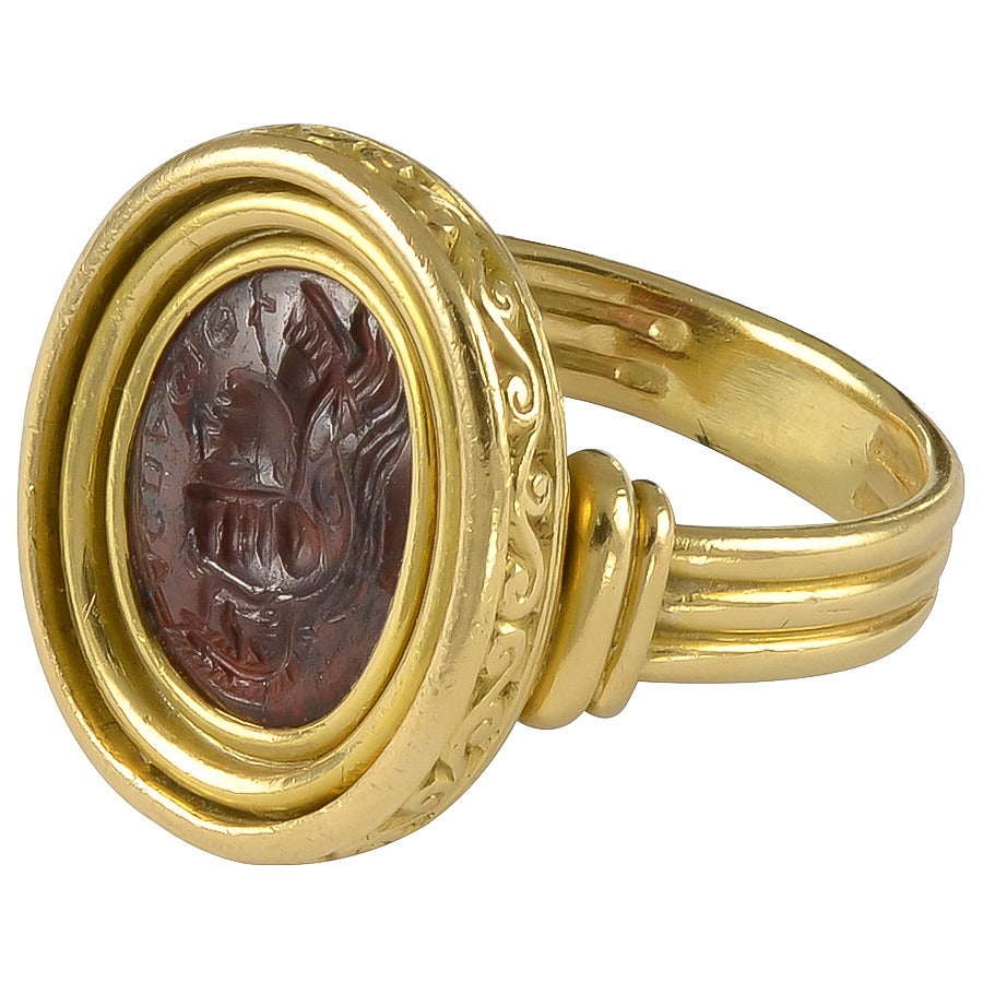 Set in an attractive Gold Ring Mount with a scrolling bezel and triple reeded shank, stamped on the outer rim with the image of an owl, one of several French
marks for 18k Gold. Engraved along the edge of the Garnet is, I am told by a knowledgable