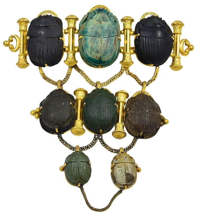The 8 Scarabs, some of which are ancient, are arranged in three graduating rows and measure in length from 2.5cm to 1.5cm. Two have readable hieroglyphics and the other 6 have Scarab carapace reverses and the 6 Gold columns resemble the Temple