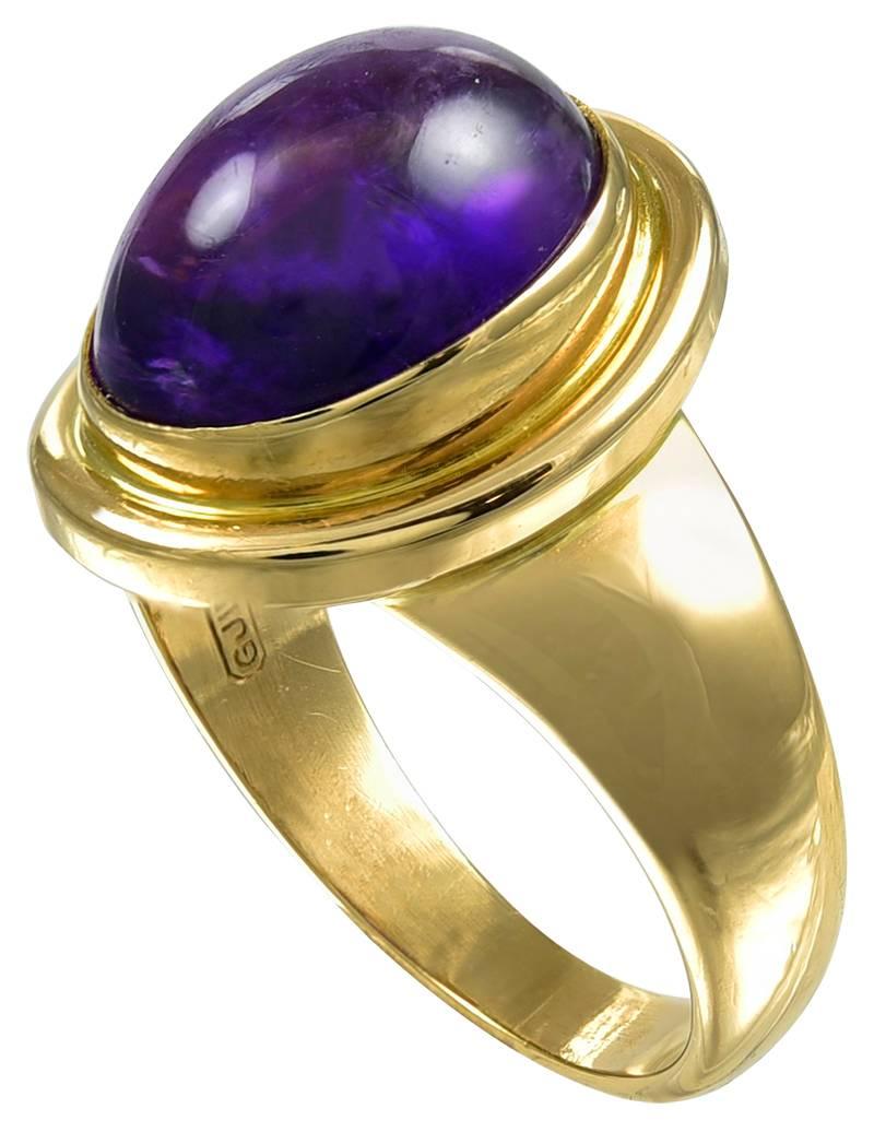 Set with an oval Cabochon of pleasing colour, in a rub over setting to a beveled bezel with plain shoulders and shank. The inner band stamped with a series of marks as follows: the Georg Jensen registered mark, 750, 1046B, GJ LD followed by English