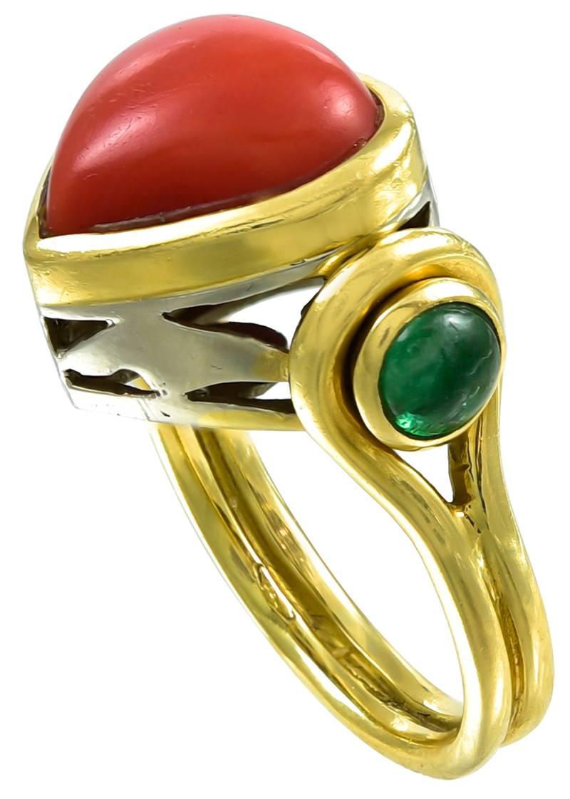 The central Coral Heart of good colour and on either shoulder, a Cabochon Emerald with a Gold loop surround which continues on to form the shank 
and the lower part of the gallery and the reverse of the head are made in 18K white Gold. The inner