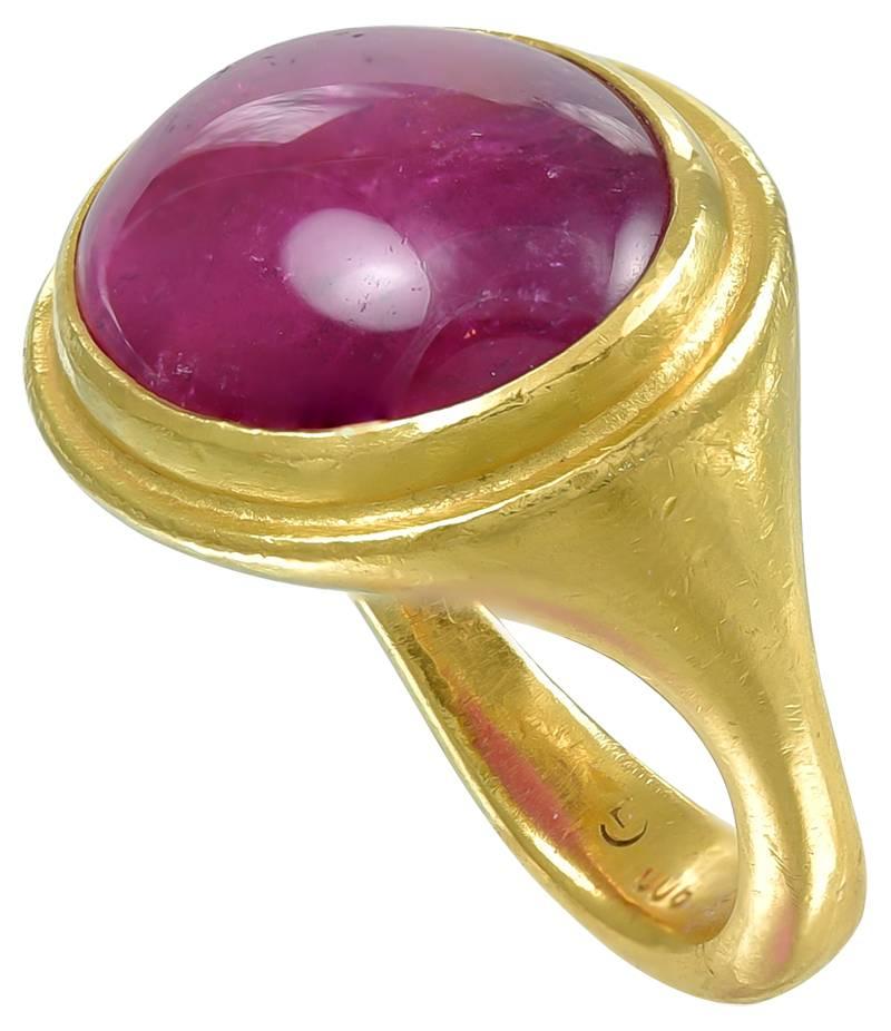 The vibrant Pink Tourmaline mounted across the finger in a rub over setting with a finely bevelled edge to plain shoulders and shank. The mount is quite heavy, being constructed of Gold which is marked 900, a Continental mark for 21.5k Gold. A very