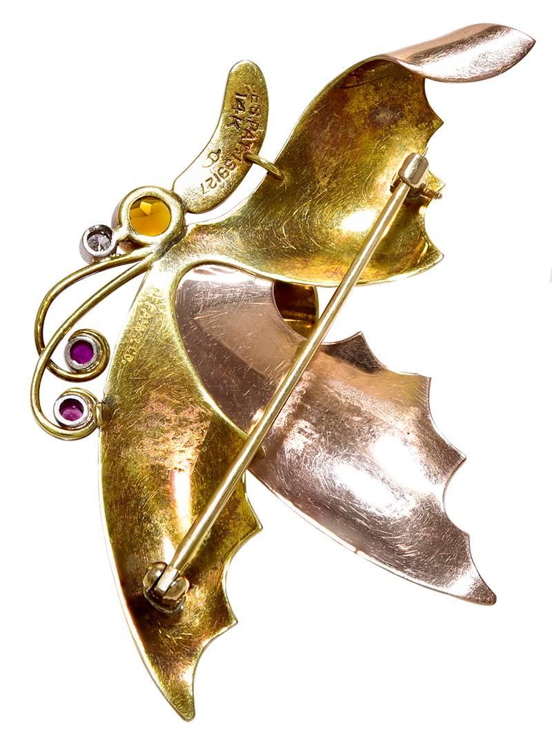 With 2 Pink and 1 Yellow Gold Wing, long antennae set with 2 Rubies and the head set with a Citrine and a Diamond. The Rubies and Diamond in Platinum topped Gold settings. The slightly abstract design is most appealing and what is that curled