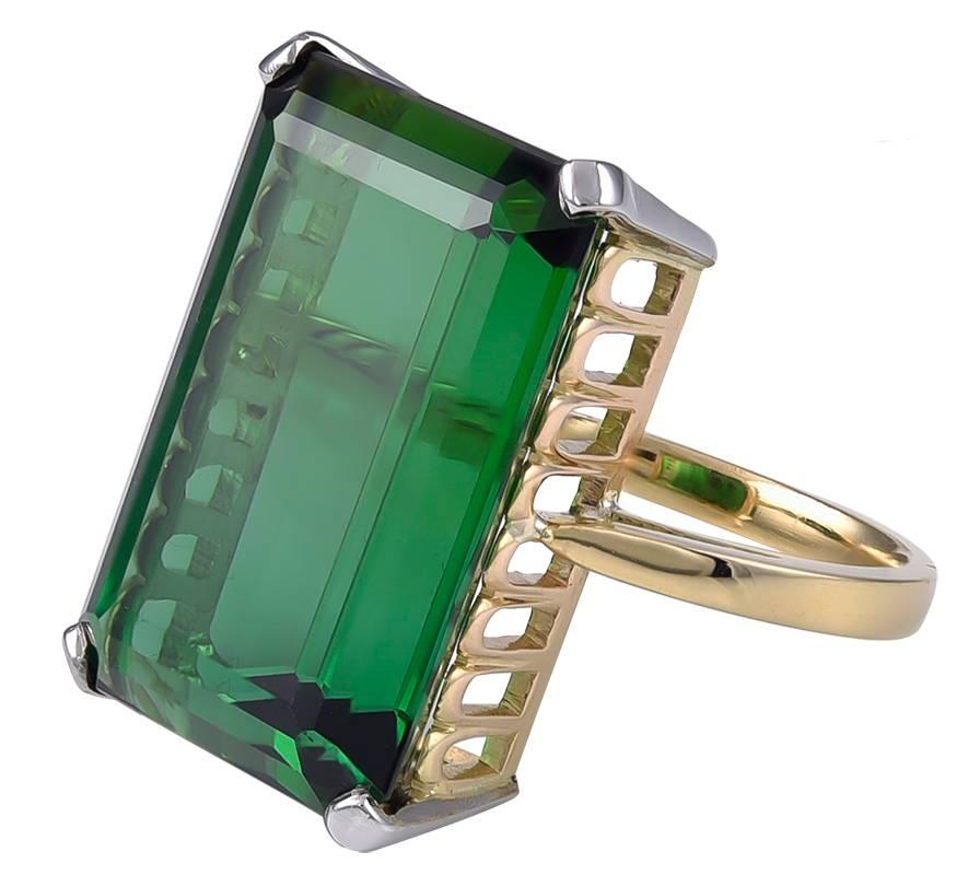 The fine Gem quality rectangular Tourmaline, weighting approximately 24 carats, set in an unmarked 18k Gold mount with a multi arched gallery and with discreet Platinum prongs at each corner. 
A really fabulous Gem with lustrous Green depths, the