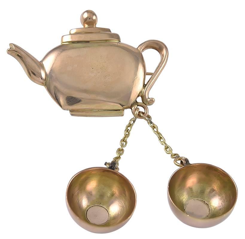 An English 1920's Tea Pot and 2 Tea Cup Brooch in unmarked 15k Gold, worn no doubt, to bring a smile to a companions face. Needless to say, the 2 Tea Cups swing with movement, catching the eye and causing compliments.  A very amusing