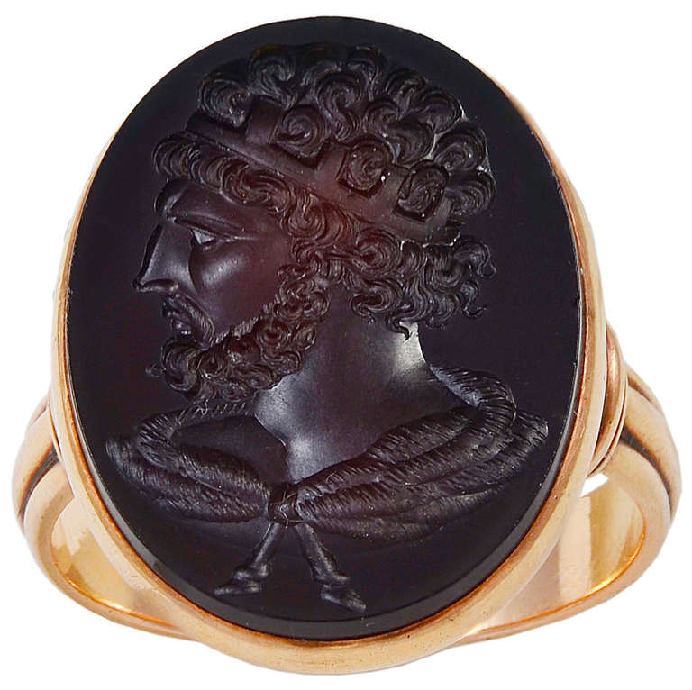 The dark brown intaglio filling the whole area of the bezel with a handsome portrait of the bearded Hadrian looking left and set in a Red Gold mount with fluted shoulders to a reeded shank.
The bezel top is 15 mm wide x 23 mm long
Finger size   10