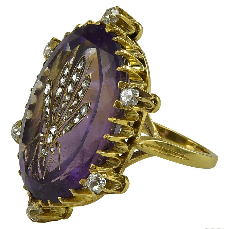 The large and beautiful Amethyst carved and inlaid with a Rose Diamond and Gold Bee, the outer margins set with six Old Mine Diamonds.
The reverse of the bezel signed Tiffany & Co and with trefoil shoulders to a slender shank. An enthralling and