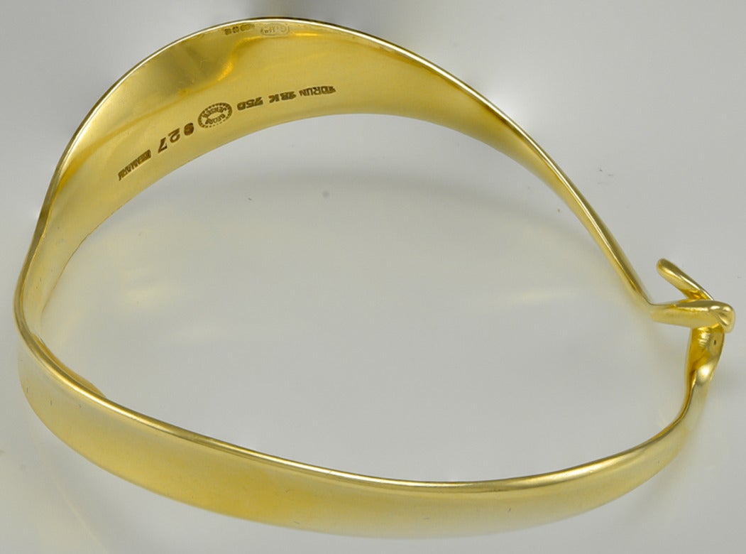 Of graceful flowing form to a cross over pressure held snap.
Stamped inside Torun  18k  750   Georg Jensen 927  Denmark
Torun (a woman), has been described as a designer who could make metal look like water flowing around the neck and