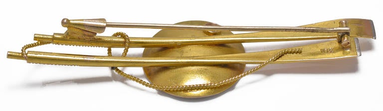 Two Gold and Platinum tipped oars which are bound with Gold Rope and support a central Disc on which is a Platinum sailed Yacht on a Platinum sea with a Diamond sun above and the reverse is stamped 18ct.
An unusual piece and was probably a unique