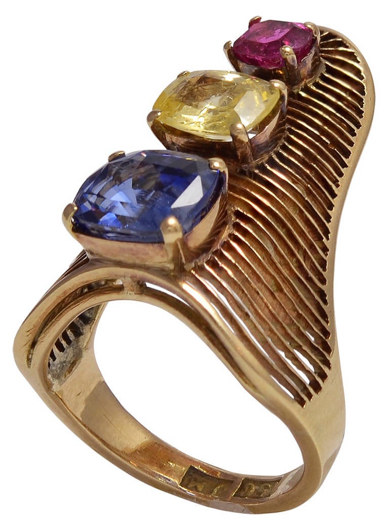 All mounted on a fine curved wire ground, the Sapphires of Blue, Yellow and Intense Pink colour in an up finger design. The inner shank stamped 15c for 15K Gold and the makers mark JM.
Good condition      Ring size:   USA  4 1/2        UK  i 1/2   