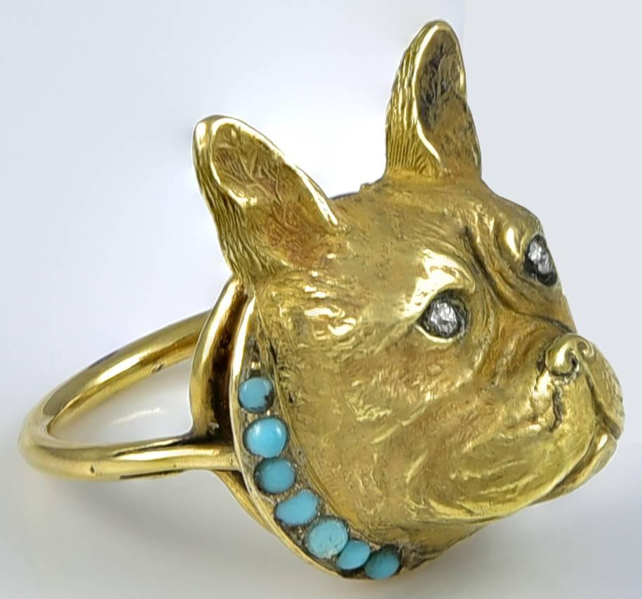 This delightful model, which was probably once a brooch or stickpin, but is now a charming Ring with a slender Gold gallery and shank. This boy is wearing a seven stone Turquoise collar and his eyes are Old European Cut Diamonds and 
he has the