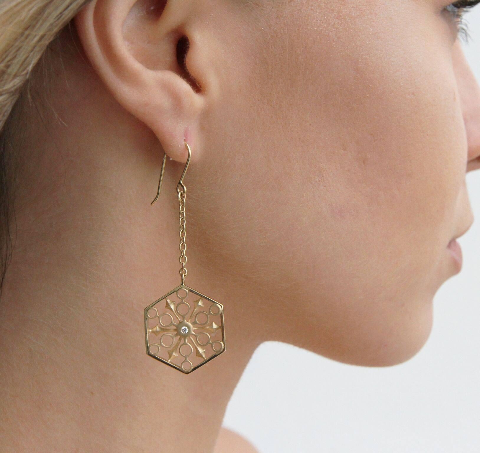 These limited edition Snowflakes Power Gold Earrings sparkle with strength. The diamonds are meant to invoke power and clarity. This piece is part of John Brevard’s THOSCENE Collection.  The 18K yellow gold earrings feature two round, white diamonds