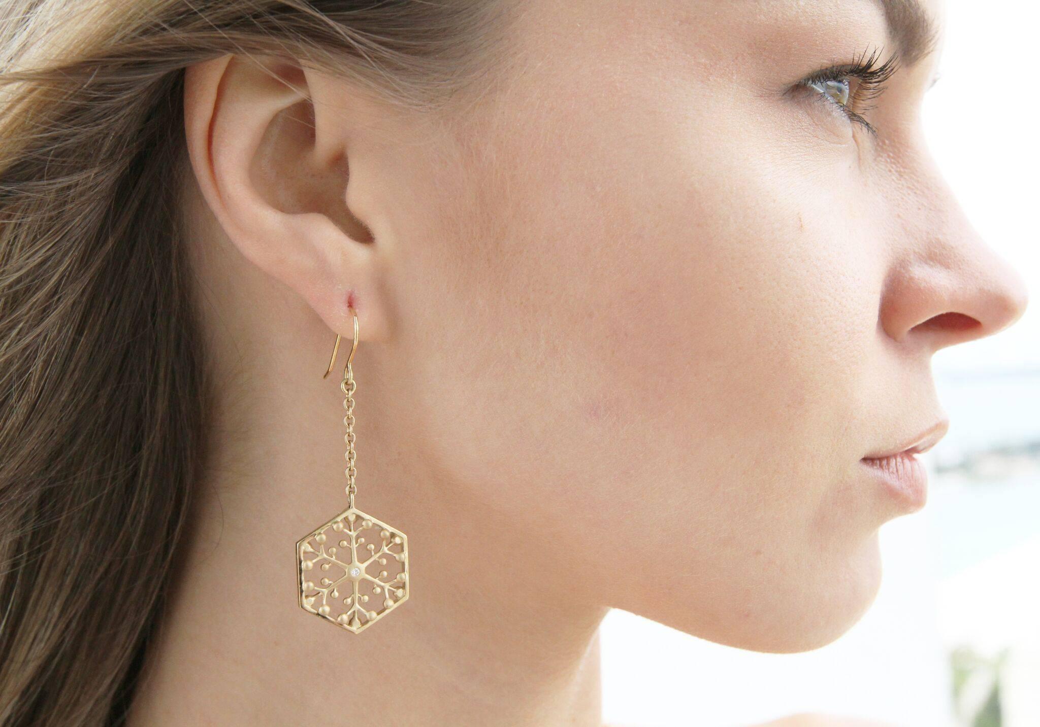 This limited edition, Snowflakes Independence 18K Gold Drop Earrings sparkle with strength. The diamonds are meant to invoke power and clarity. These statement earrings represents exploding stars, with a sparkling diamond in the center. This piece