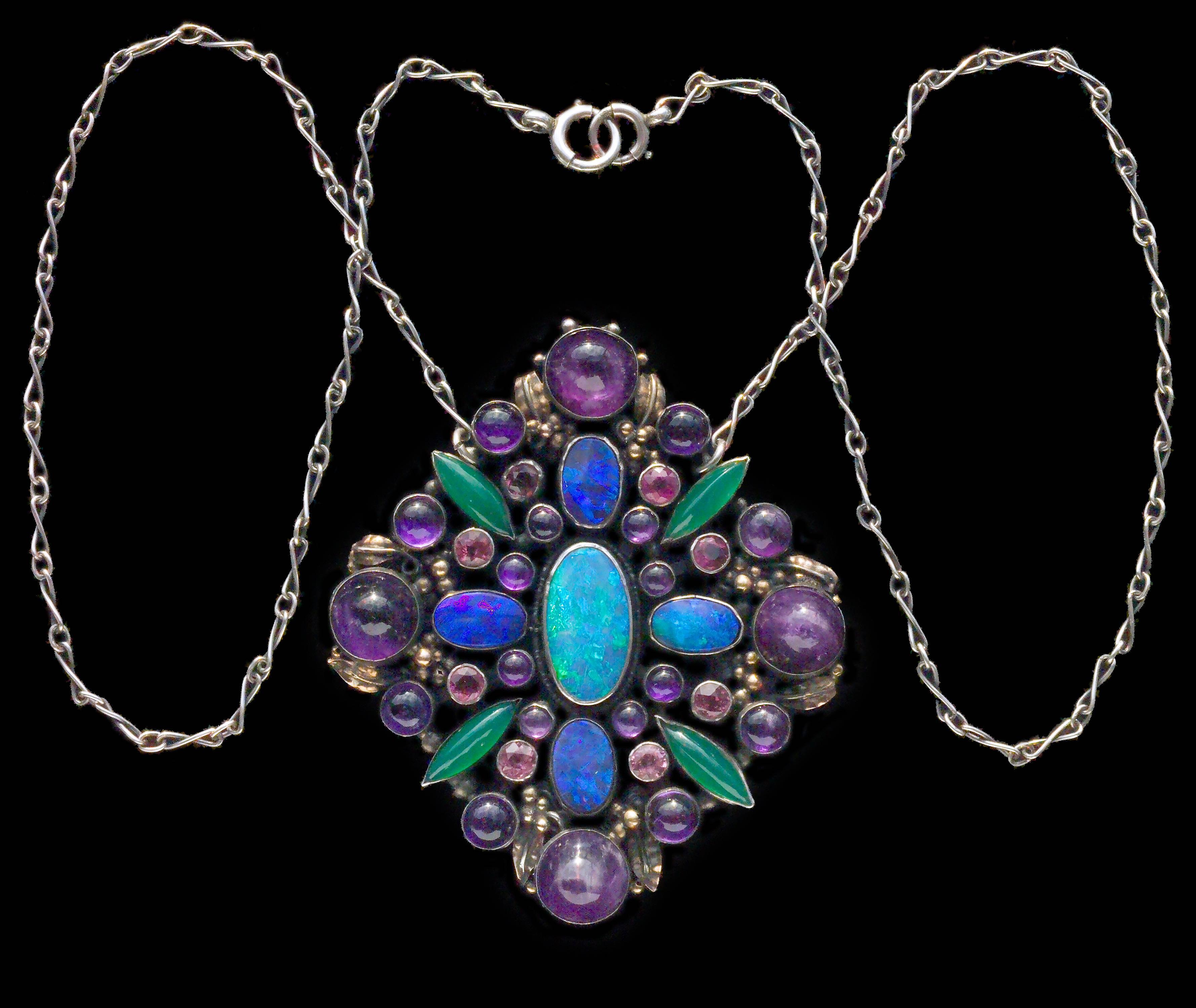 An impressive Arts & Crafts pendant with a sumptuous collection of gemstones. 