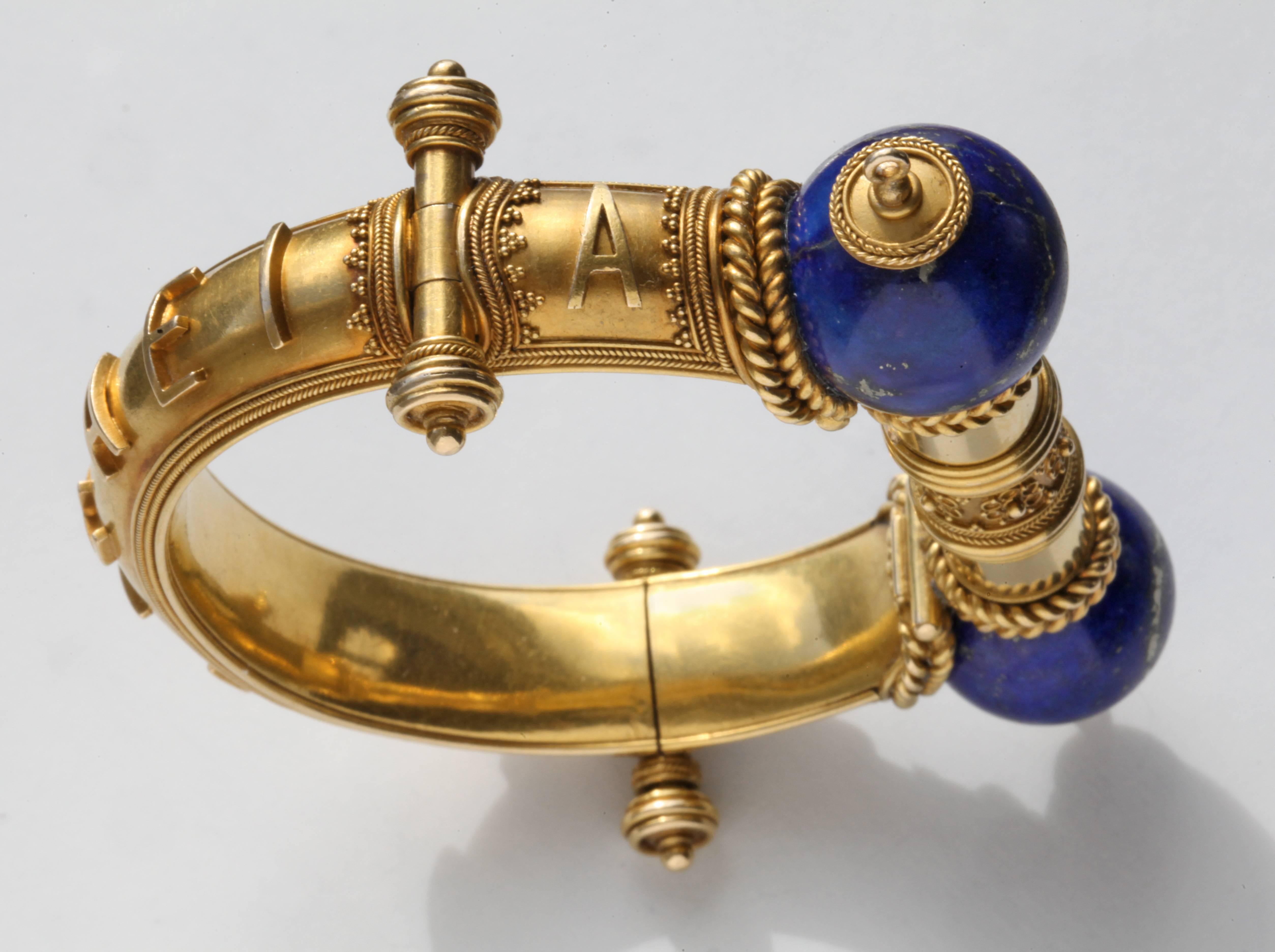A stunning Victorian gold & lapis lazuli hinged bangle, beautifully made probably by John Brogden. The Etruscan revival design has stylized hinges with locking post clasp, applied scrolled wire work and bead detail. Applied lettering to the band,