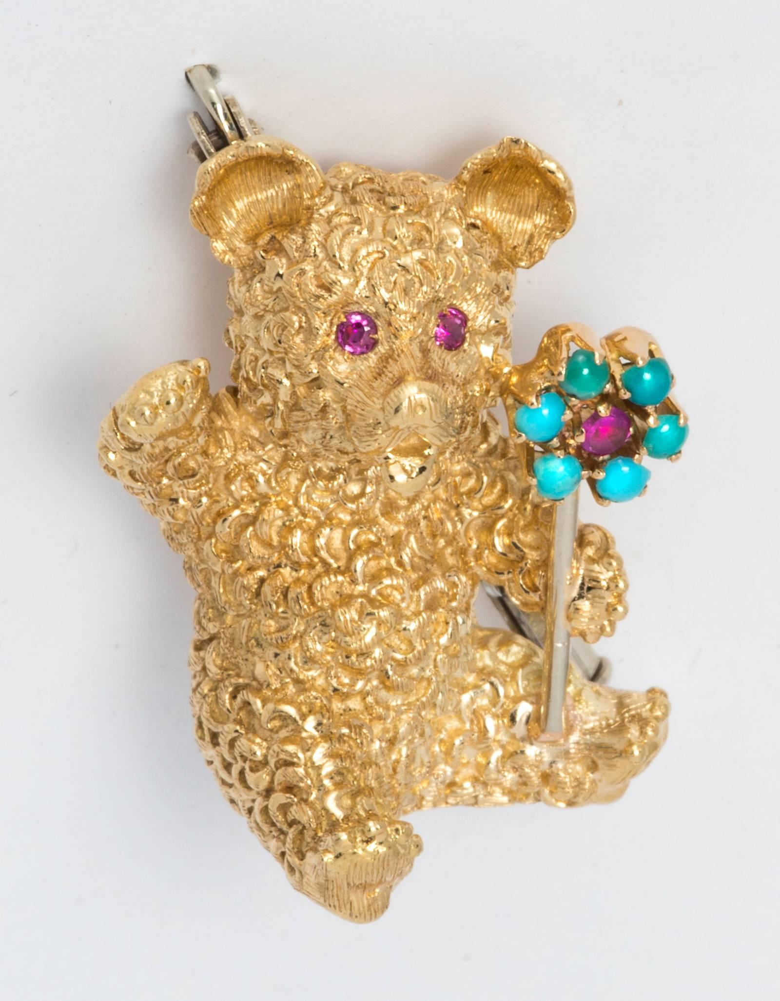 Very charming Teddy Bear waving, holding a flower.
Cartier Italy, 750, 18k yellow gold, ruby center turquoise flower, and ruby eyes.
14.5g.  1