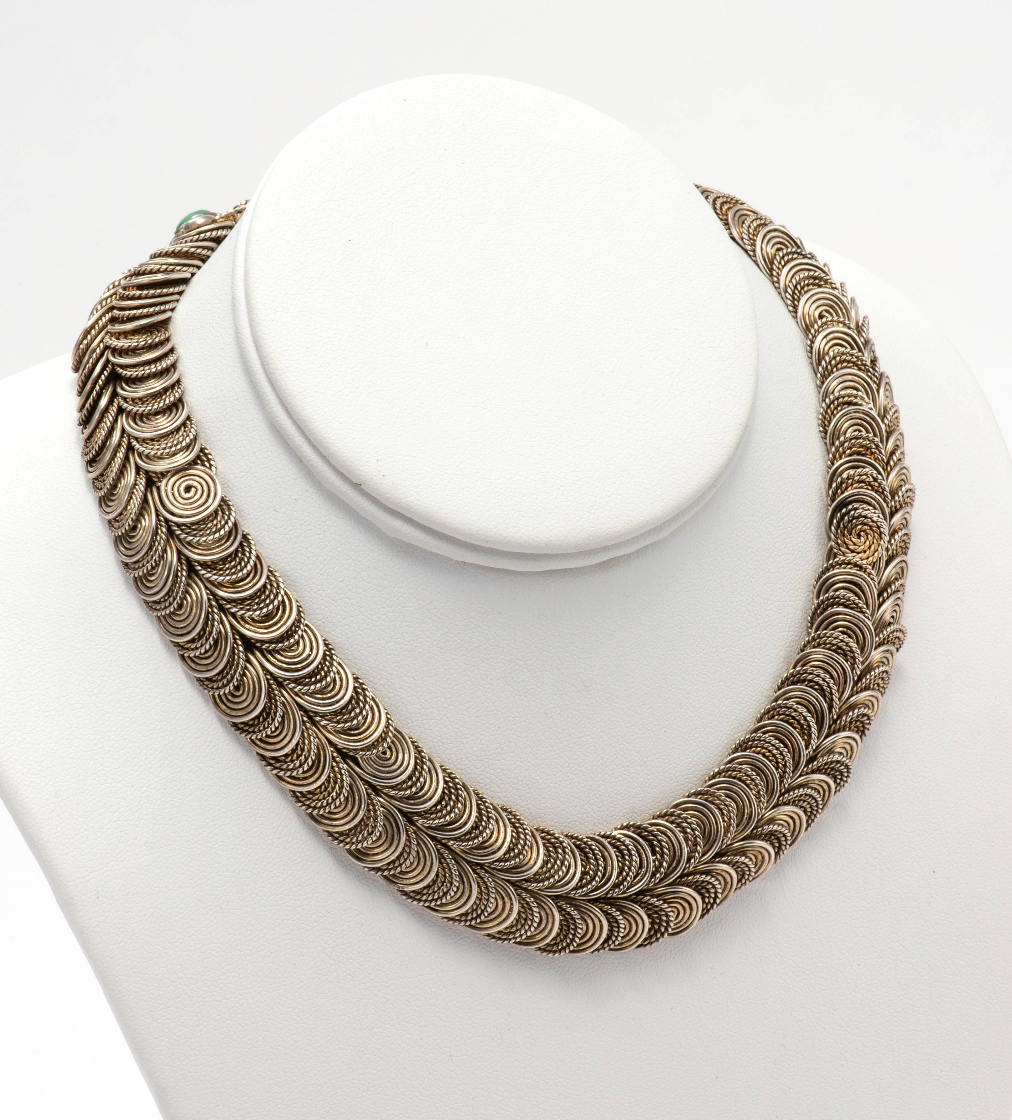 By Matilda Poulat.  C. 1950s.  Sinuous with movements, individual links in sterling silver.  Snake head clasp is adorned with setting of turquoise and coral.  
Great feel and weight.  128g.  15,5