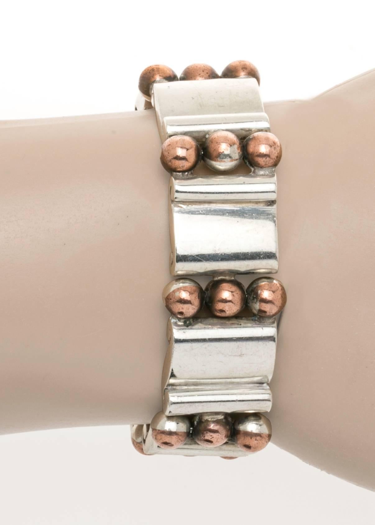 Sterling silver accented with copper balls.  Reversible hinged bracelet by Hector Aguilar of Taxco Mexico.