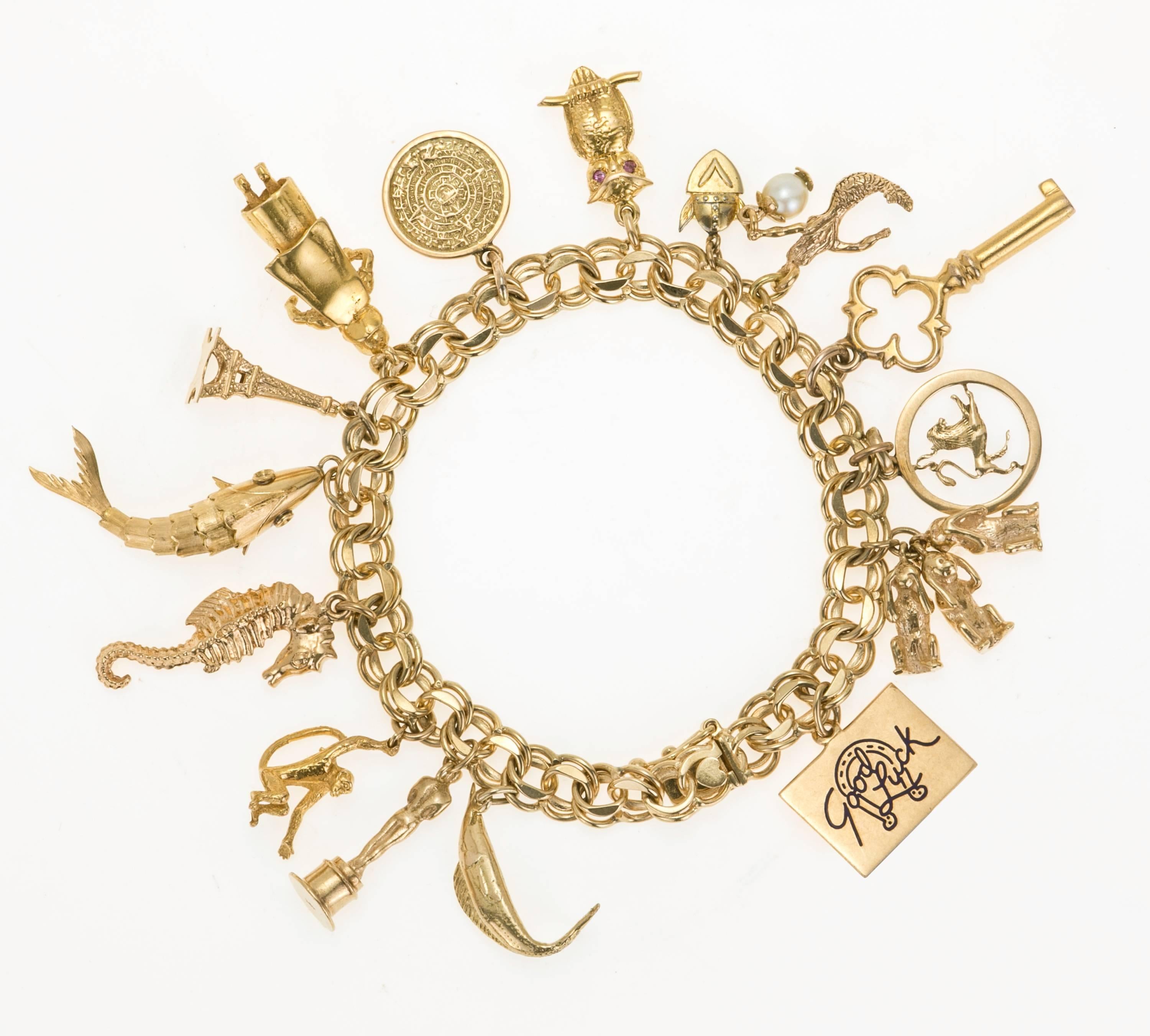   14 kt  yellow gold double chain, ladies charm bracelet with 15 charms. Following:   14 kt and enamel good luck charm, 14 kt three monkeys – see no evil -speak no evil -hear no evil. 14 kt  zodiac – Leo, 14 kt key, 14 kt mermaid and pearl , Gold