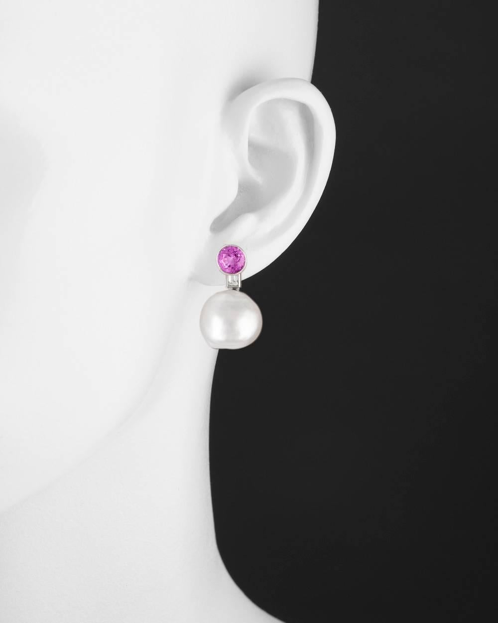 Drop earrings, showcasing a cultured South Sea baroque pearl drop suspended from a baguette-cut diamond to the bezel-set circular-cut pink sapphire tops, mounted in platinum. Two pink sapphires weighing approximately 3.42 total carats. Clip backs.
