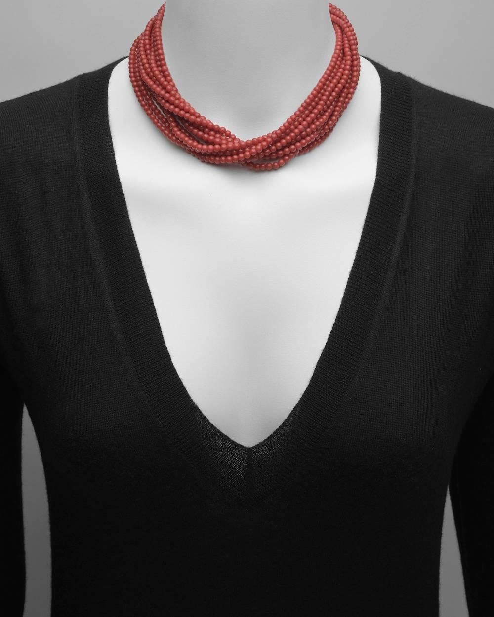 Torsade necklace, composed of ten strands of red coral beads each measuring approximately 3.5 to 4mm in diameter, the necklace secured by a 22k yellow gold clasp. 16