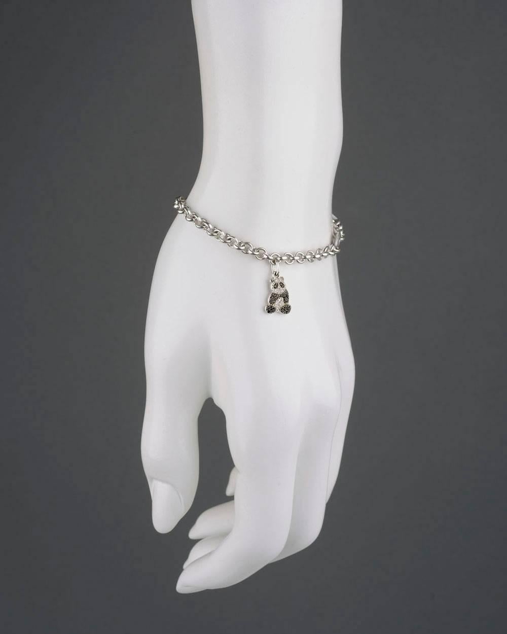 Charm bracelet in 18k white gold, designed as a fine oval-shaped link bracelet, suspending a black and white pavé diamond Panda charm, the diamonds weighing approximately 0.22 total carats, the bracelet with an oval-shaped plaque link signed