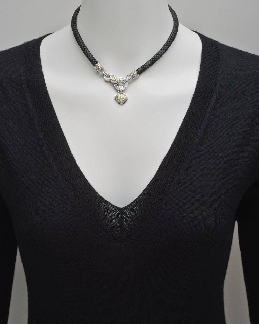 Braided black leather cord necklace, with textured sterling silver and 18k yellow gold heart pendant at center, the heart with a pavé-set diamond center with small round diamond accents in 18k yellow gold mounts, signed Judith Ripka. 15.75