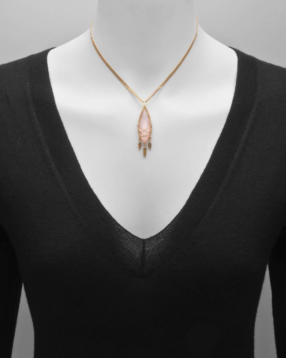 Rose quartz pendant necklace in a handcrafted, 18k yellow gold wire setting, suspending gold drops. On a handmade chain necklace in 18k yellow gold that adjusts from 15
