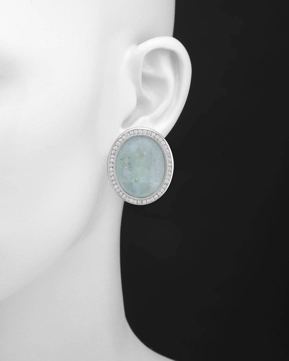 Oval-shaped aquamarine and diamond earrings, composed of a large cabochon-cut aquamarine surrounded by round diamonds, the pair of aquamarines weighing approximately 68 total carats and diamonds weighing approximately 1.84 total carats, mounted in