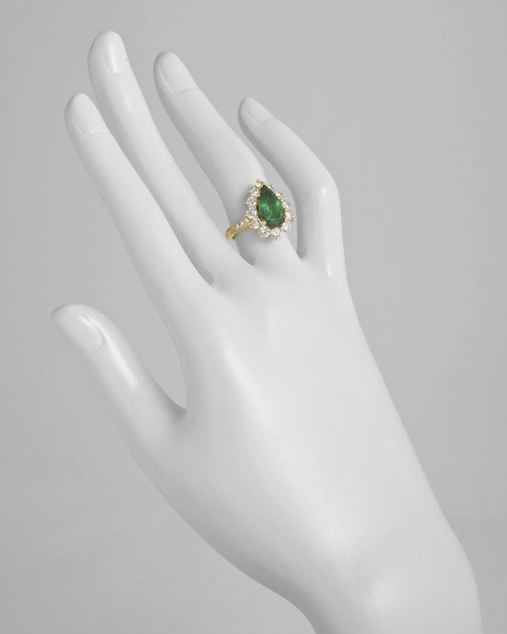 Emerald and diamond cluster ring, centering a pear-shaped emerald weighing approximately 2.44 carats within a round diamond surround with round diamond accented shoulders, the diamonds weighing approximately 1.60 total carats, mounted in 18k yellow