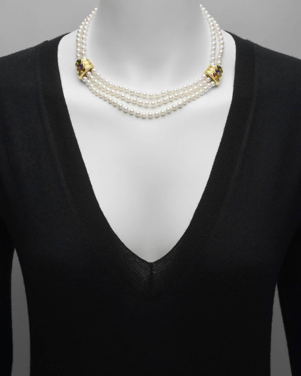 Pearl necklace, comprising three rows of cultured pearls at the front, gathered by a pair of 18k yellow gold ribbed panels, the panels accented by oval-shaped cabochon green tourmaline, amethyst and citrine, to the two rows of cultured pearls at
