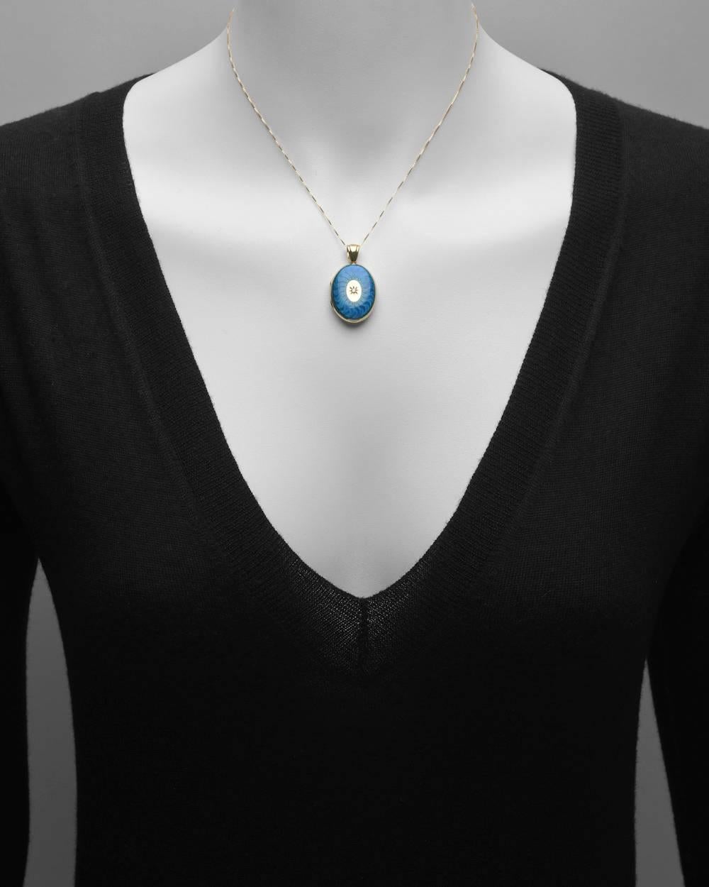 Enamel, diamond and gold oval locket pendant, designed as an oval gold locket with royal blue enamel and a single diamond at the center, in 18k yellow gold, signed Charles Green. 25mm length without bale (with bale, 33mm) and 19mm width at widest
