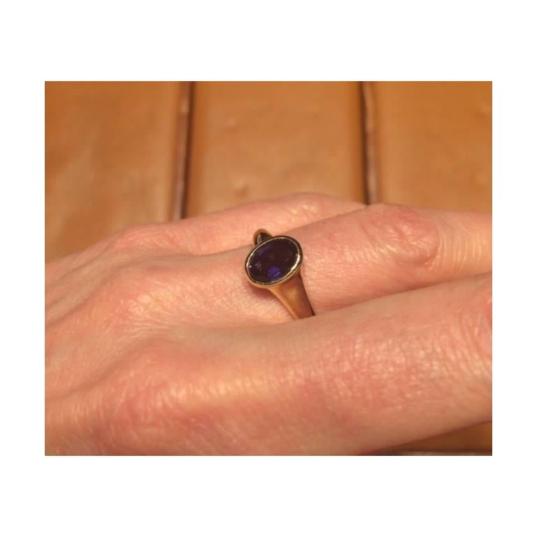 Bezel-set iolite ring in 18k yellow gold centering an oval iolite, the iolite weighing approximately 0.95 carats and measuring approximately 8 x 6mm from the top, signed Bulgari. Size 6 (resizable to most ring sizes). 
