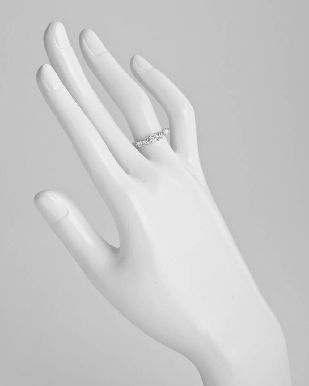 Three diamond ring, designed with a larger center circular cut diamond flanked by two smaller circular cut diamonds, in platinum, signed Dior, style number 600. Diamonds weighing approximately 0.221 total carats. Ring size 5.75. 