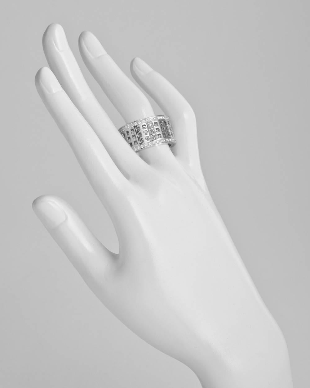 Wide spinning band ring, showcasing an intricate double-layered pattern of cutout squares in polished white gold at center, the top layer designed to spin, flanked by rows of pavé diamonds on either side, in 18k white gold, made in Italy, signed