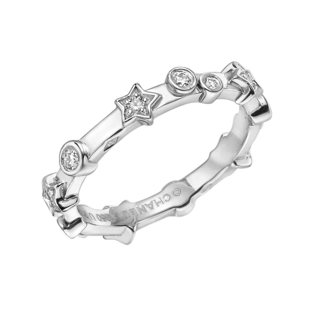 Band ring, accented by bezel-set diamonds and star motifs each centering a round-cut diamond, in platinum, numbered U32836, signed Chanel. Diamonds weighing approximately 0.15 total carats. Size 4.75 (49 - European). 3.4mm band width at widest part