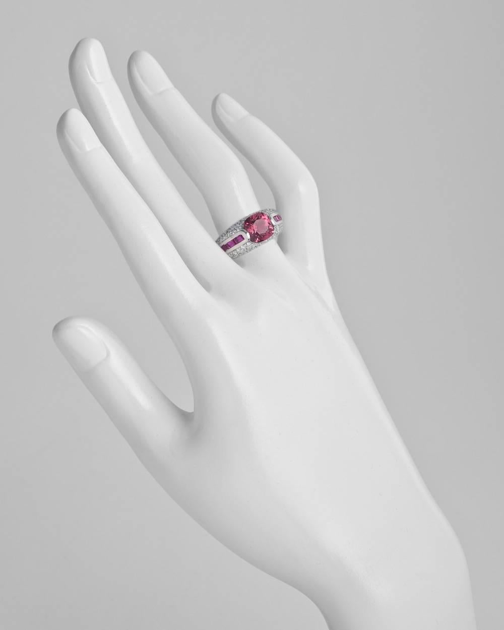 Pink tourmaline, ruby and diamond ring, centering a modern cushion-shaped pink tourmaline with baguette-cut ruby shoulders and pavé diamond accents, mounted in 18k white gold, mounting marked 