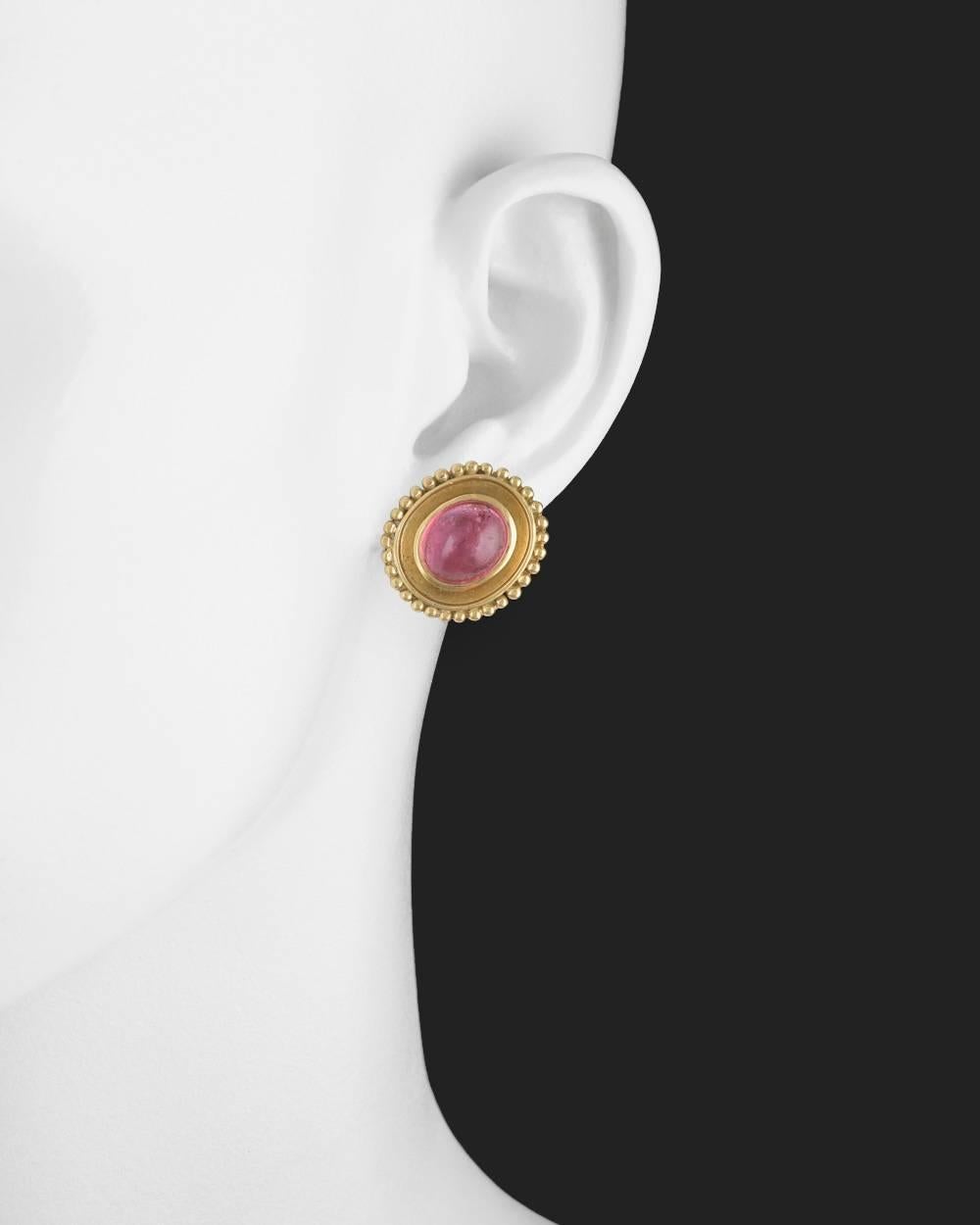 Pink tourmaline and yellow gold earclips, each centering an oval cabochon pink tourmaline bezel-set in 18k yellow gold setting with a gold beading around the edges. Omega clip backs with posts. Each measuring 0.83