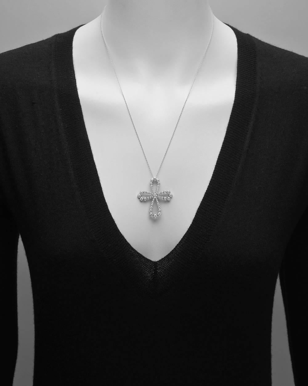 Diamond cross pendant necklace, bezel-set with circular-cut diamonds of graduated size, mounted in platinum, on a 21