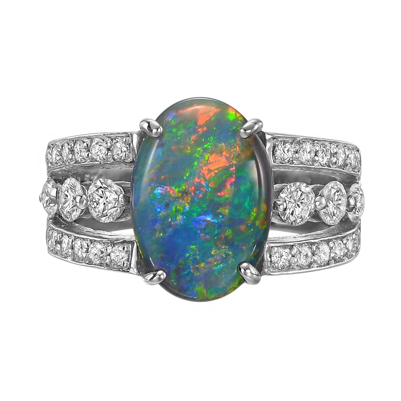 Dress ring, centering an oval-shaped black opal weighing approximately 2.58 carats, with a three-row diamond shank, the diamonds weighing 0.68 total carats, in platinum. Size 6.25