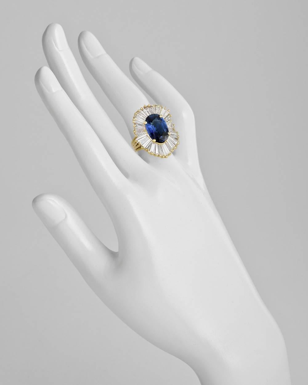 'Ballerina'-style sapphire and diamond ring, showcasing an oval-shaped sapphire weighing approximately 6.14 carats, the sapphire set within a tapered baguette-cut diamond surround, the diamonds weighing approximately 4.04 total carats (G-H color,