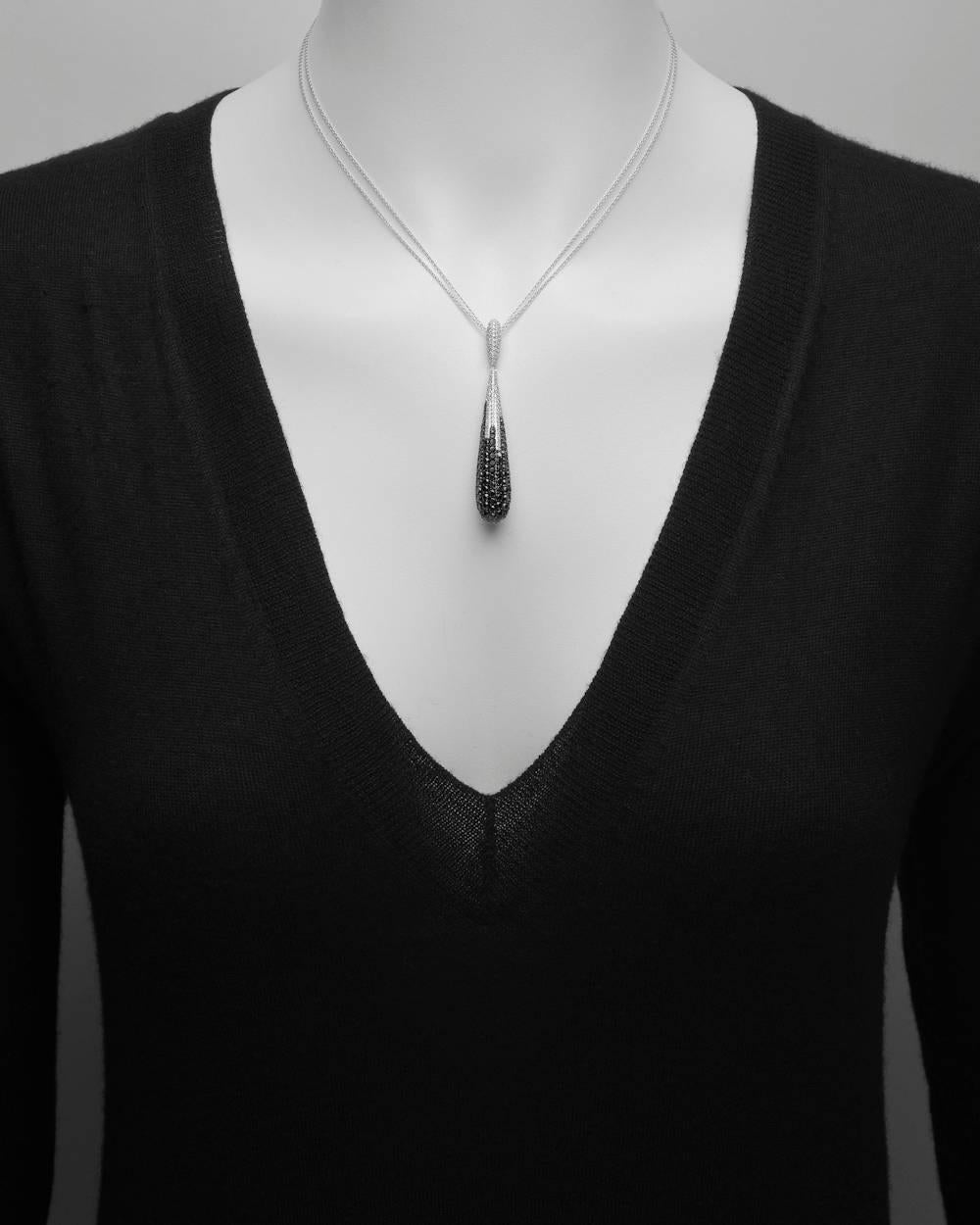 Elongated teardrop pendant necklace, set with 91 round black diamonds weighing approximately 2.28 total carats and 125 round near-colorless diamonds weighing approximately 0.94 total carats (G-color, SI-clarity), in 14k white gold, stamped 'YA'. The