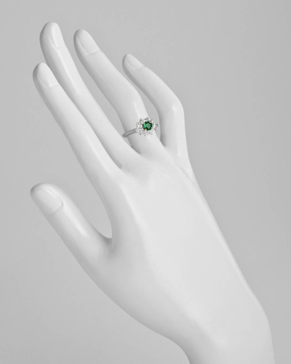 Emerald and diamond cluster ring, centering a circular-cut emerald weighing approximately 0.32 carats, surrounded by six round and four marquise-shaped diamonds, the diamonds altogether weighing approximately 0.56 total carats (F color, VVS1-VVS2