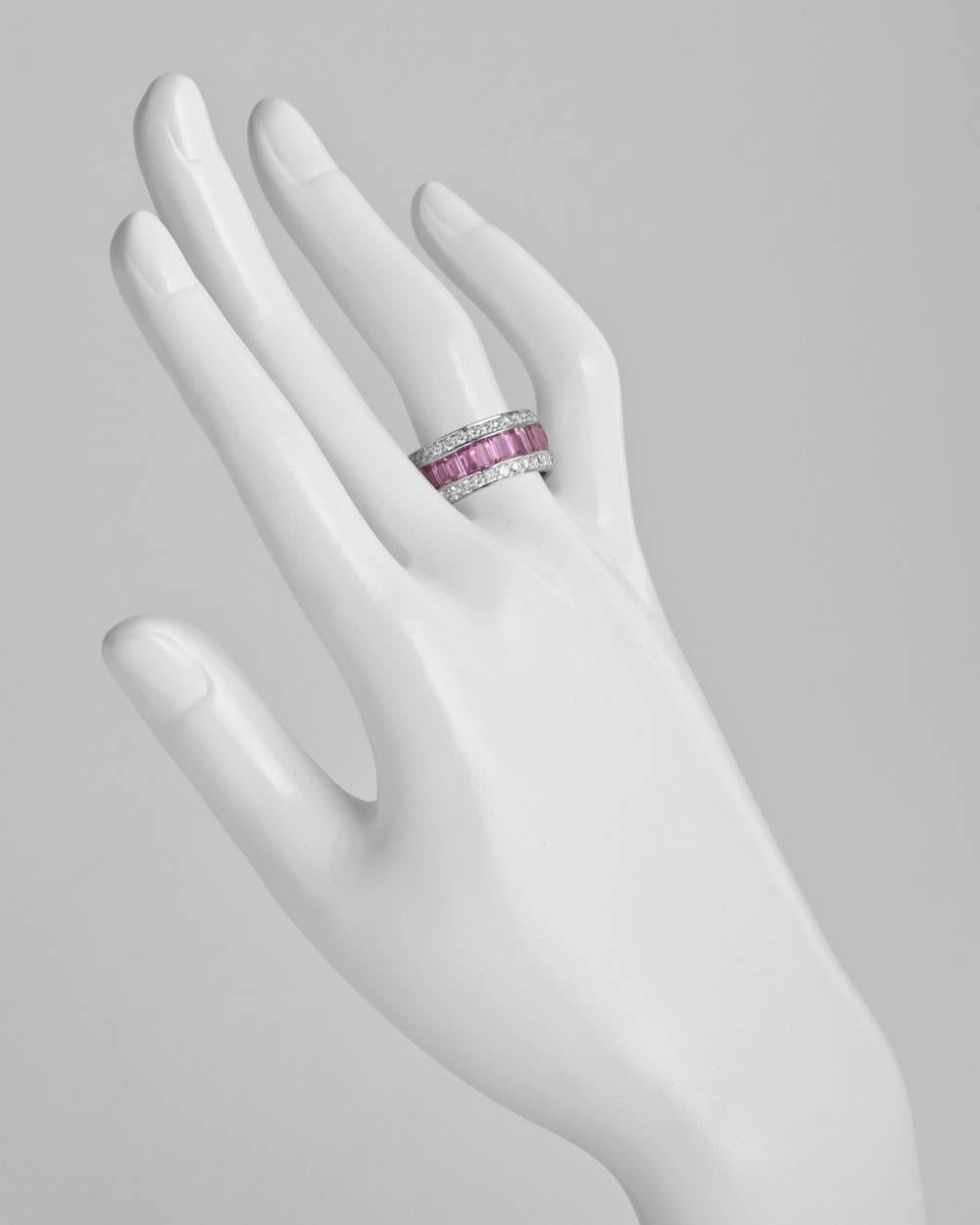 Three-row eternity band, centering a row of larger baguette-cut pink sapphires bordered by round brilliant-cut diamonds, mounted in 18k white gold. Pink sapphires weighing approximately 8.01 total carats and diamonds weighing approximately 1.75