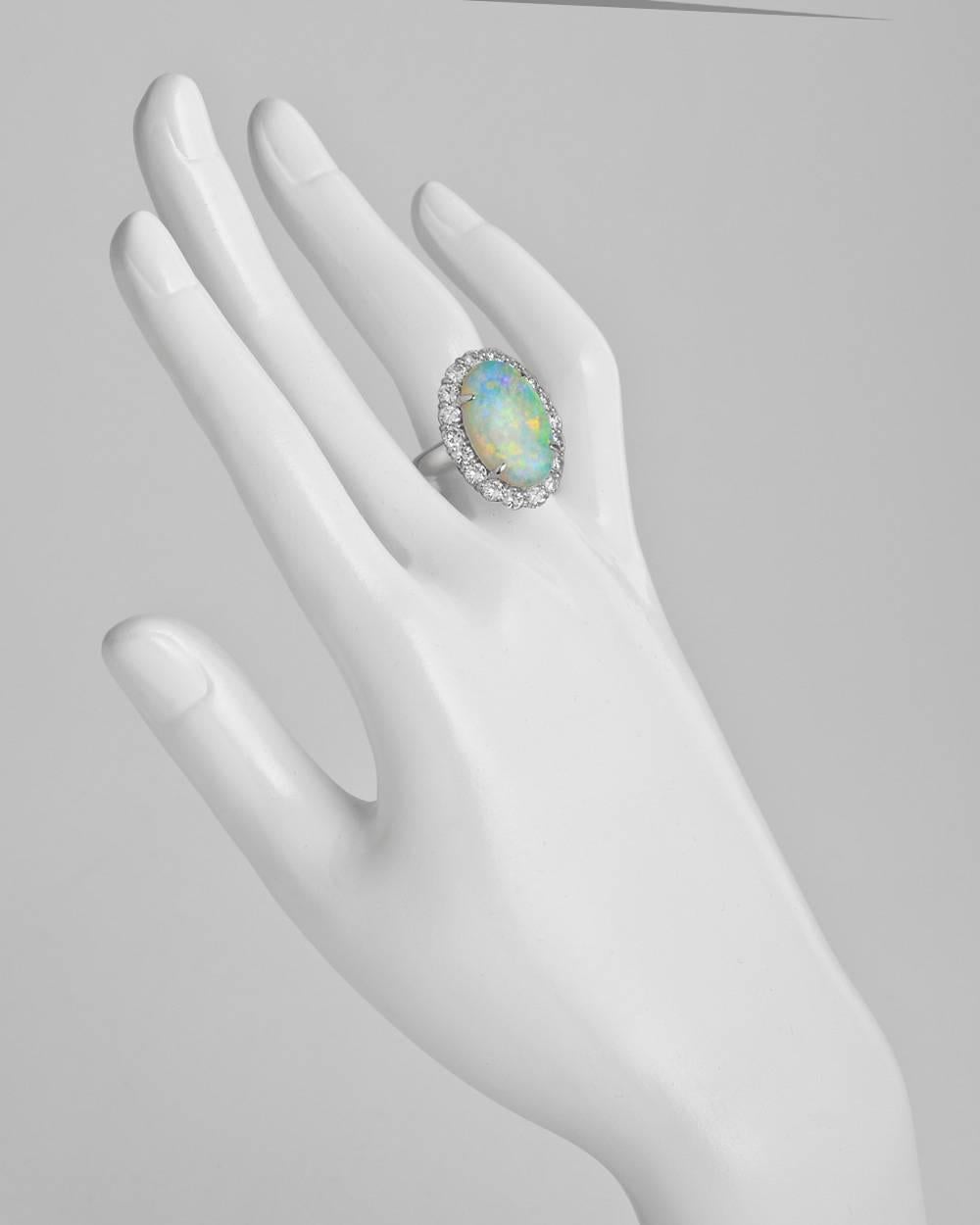 Cocktail ring, centering an oval-shaped opal weighing approximately 6.71 carats, the opal surrounded by round brilliant-cut diamonds weighing approximately 2.00 total carats, in platinum. Size 6.