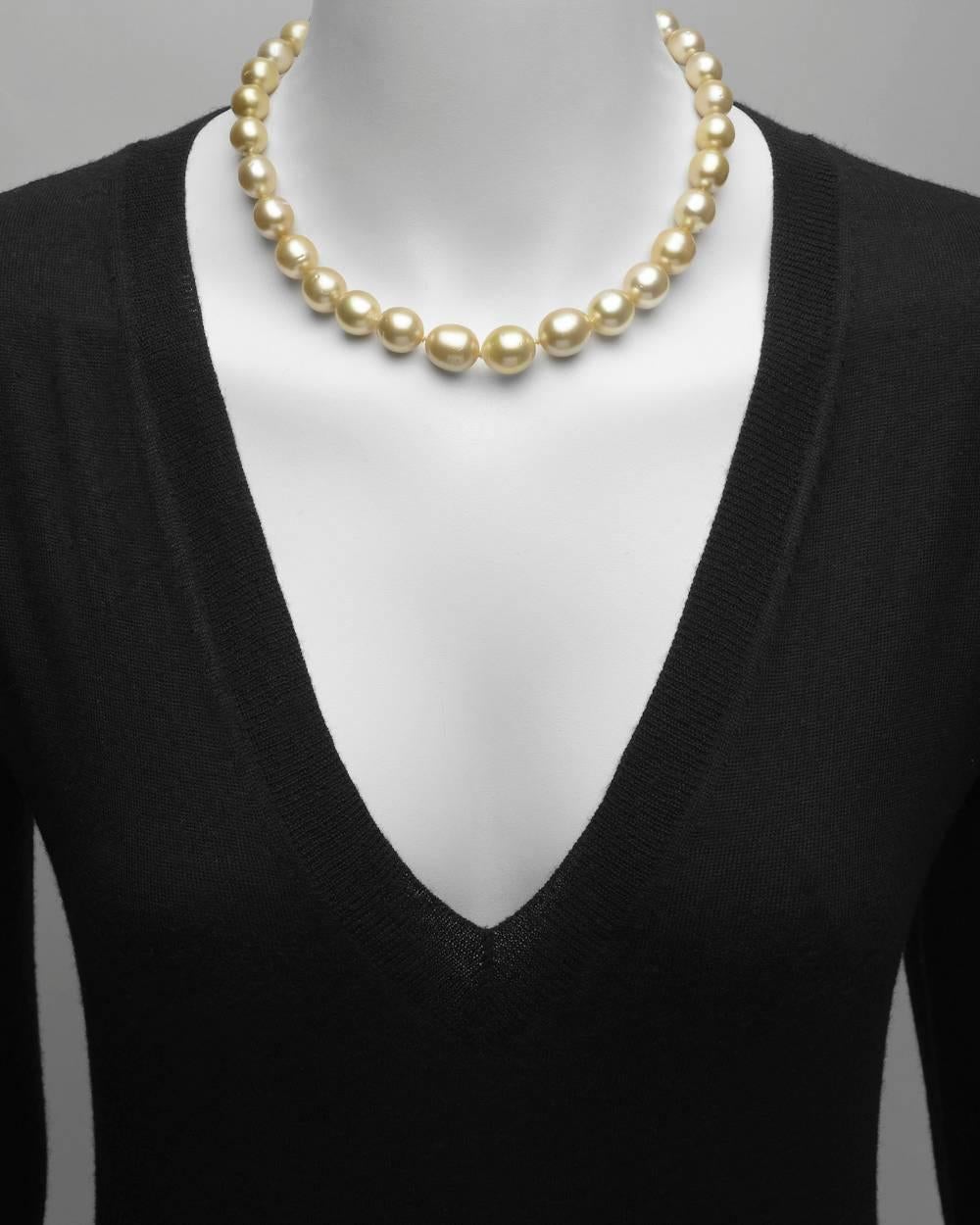 Golden South Sea pearl necklace, composed of 33 cultured pearls ranging from 13.7mm to 9.7mm in diameter, strung on a hand-knotted silk cord, secured by an 18k yellow gold and pavé yellow sapphire ball clasp with two round diamond accents. Yellow
