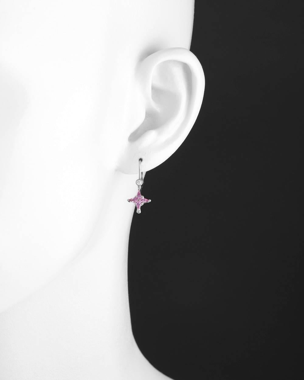 Drop earrings, each designed as a four-pointed star motif composed of pink sapphires to the bezel-set diamond surmount, in 18k white gold, with French wires and leverbacks for pierced ears. Eight kite-shaped pink sapphires weighing approximately