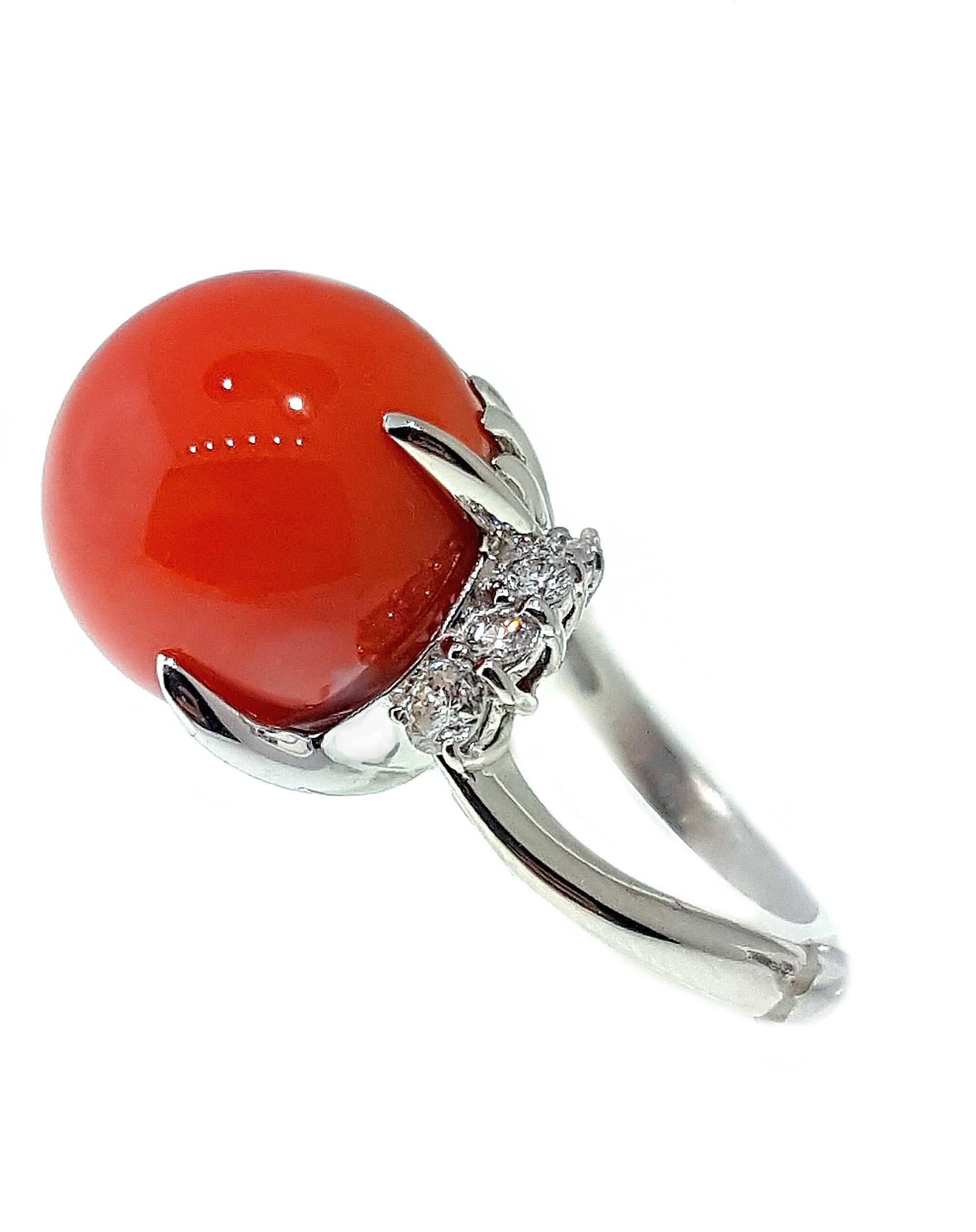 Striking high polished platinum ring featuring a 21.81ct, 14.6mm red coral ball accented by 2 waves of graduated full cut, round brilliant diamonds totaling .39ct. The diamonds are approximately SI1-2 in clarity and H-I in color.  The ring is a US