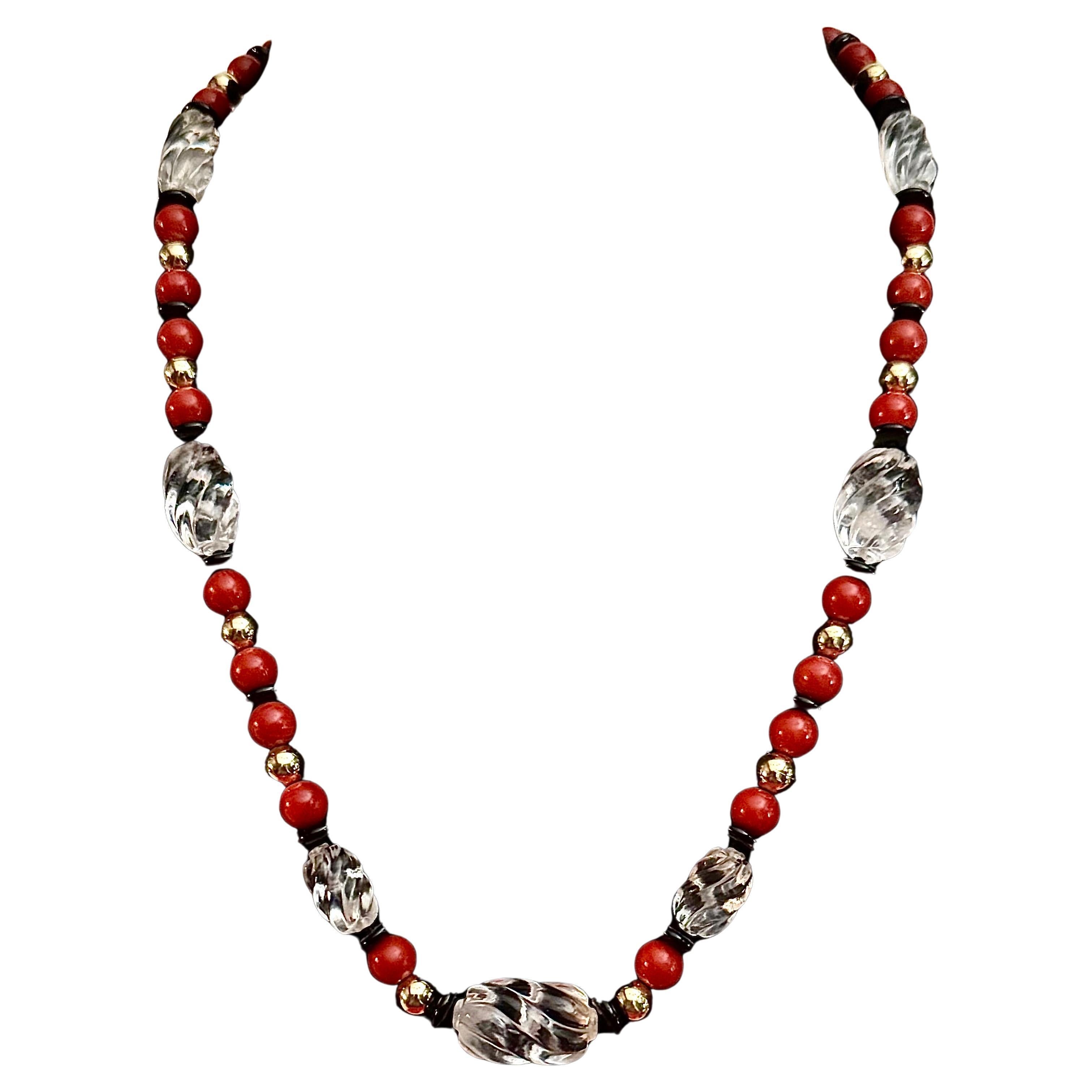 Corallo rosso, cristallo di rocca, rondelle d'oro e onice nera.